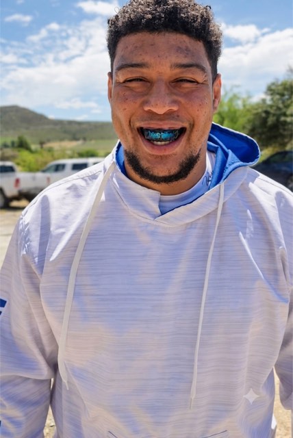 A Snugfit athlete wearing his custom teal mouthguard